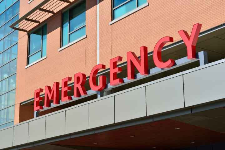 Photo: A sign is displayed on a building with letters that spell "Emergency."