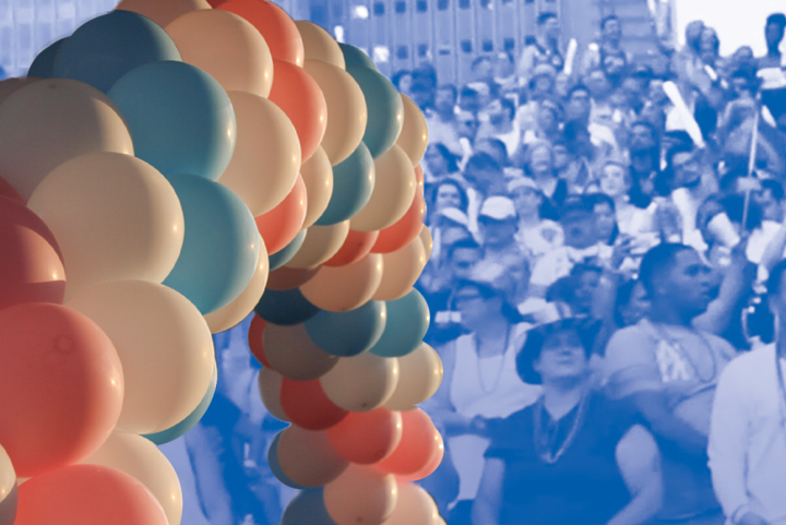 Image: An image of balloon arch with alternating trans pride colors overlaps a stylized image of a crowd of people gathered.