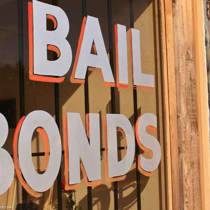 Image of a hand painted sign that reads "Bail Bonds" on a window