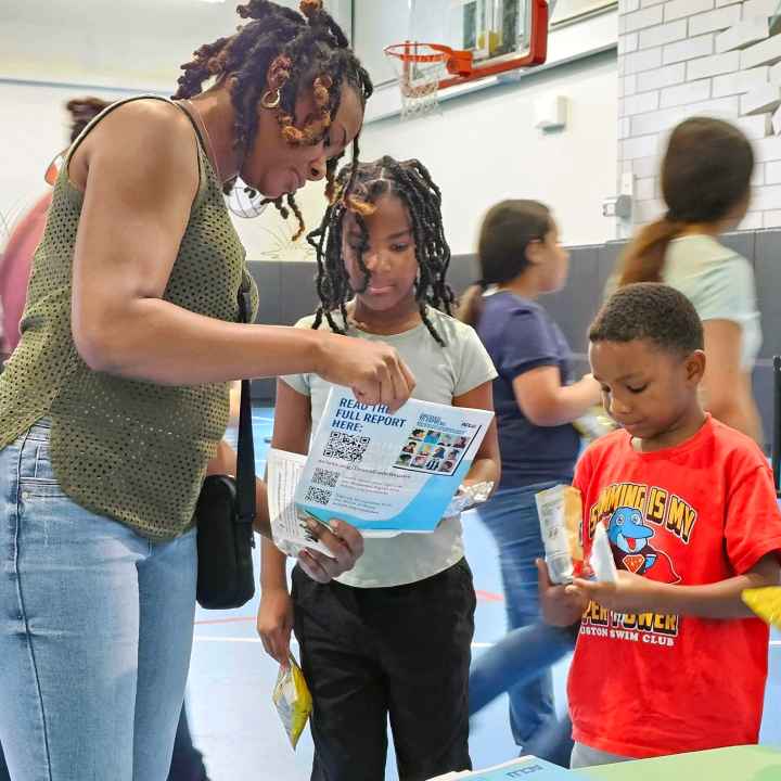 An adult and two children learn about the Students' Rights Hub