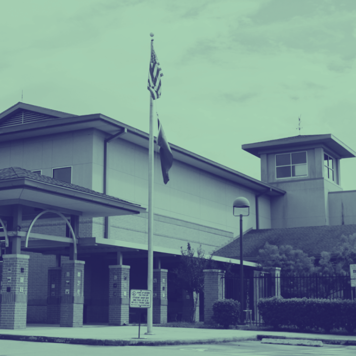 Image: A stylized photo shows a school building with a flag pole in front.