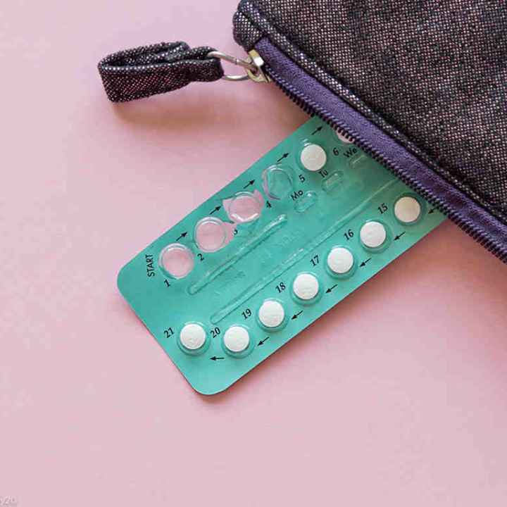 Photo: An aluminum packet of small circular pills has a few missing, the spots where they were punched out of the aluminum visible. The packet peacks out of a zipper pouch. 